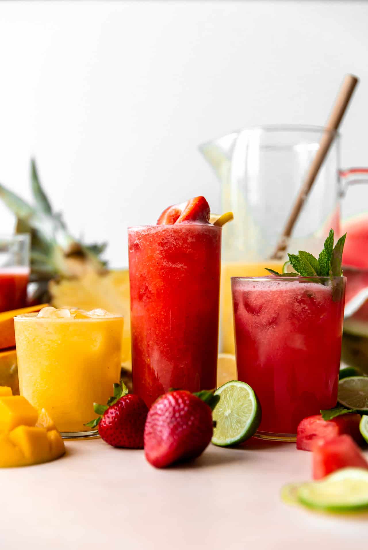 Les verres d'agua fresca sont alignés avec des fraises, des pastèques et des ananas-mangues.