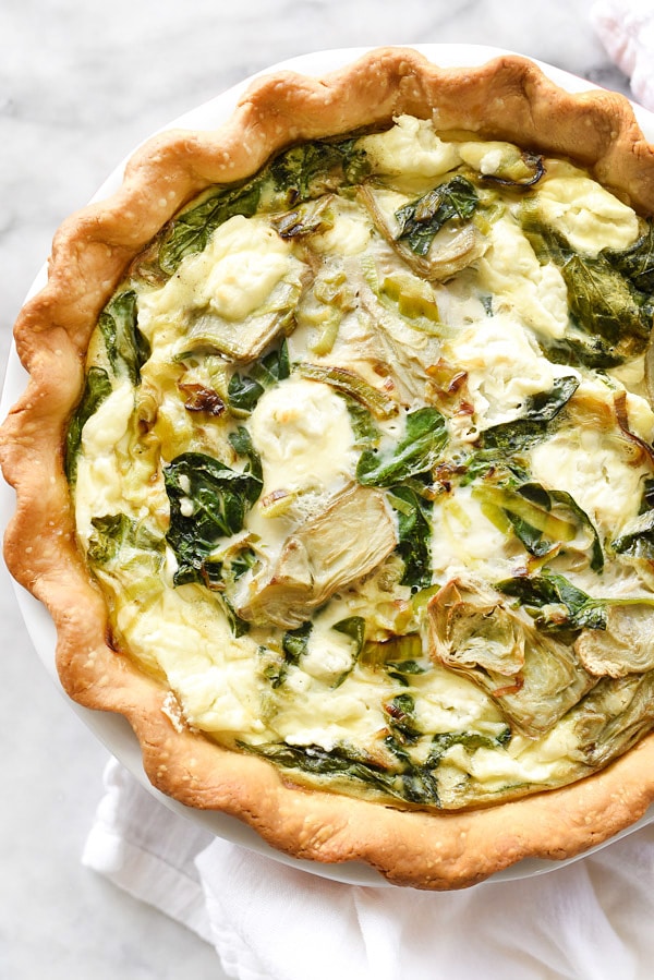 La quiche aux épinards, aux artichauts et au fromage de chèvre est une quiche simple et savoureuse à base de lait d'amande et de crème pâtissière aux œufs.