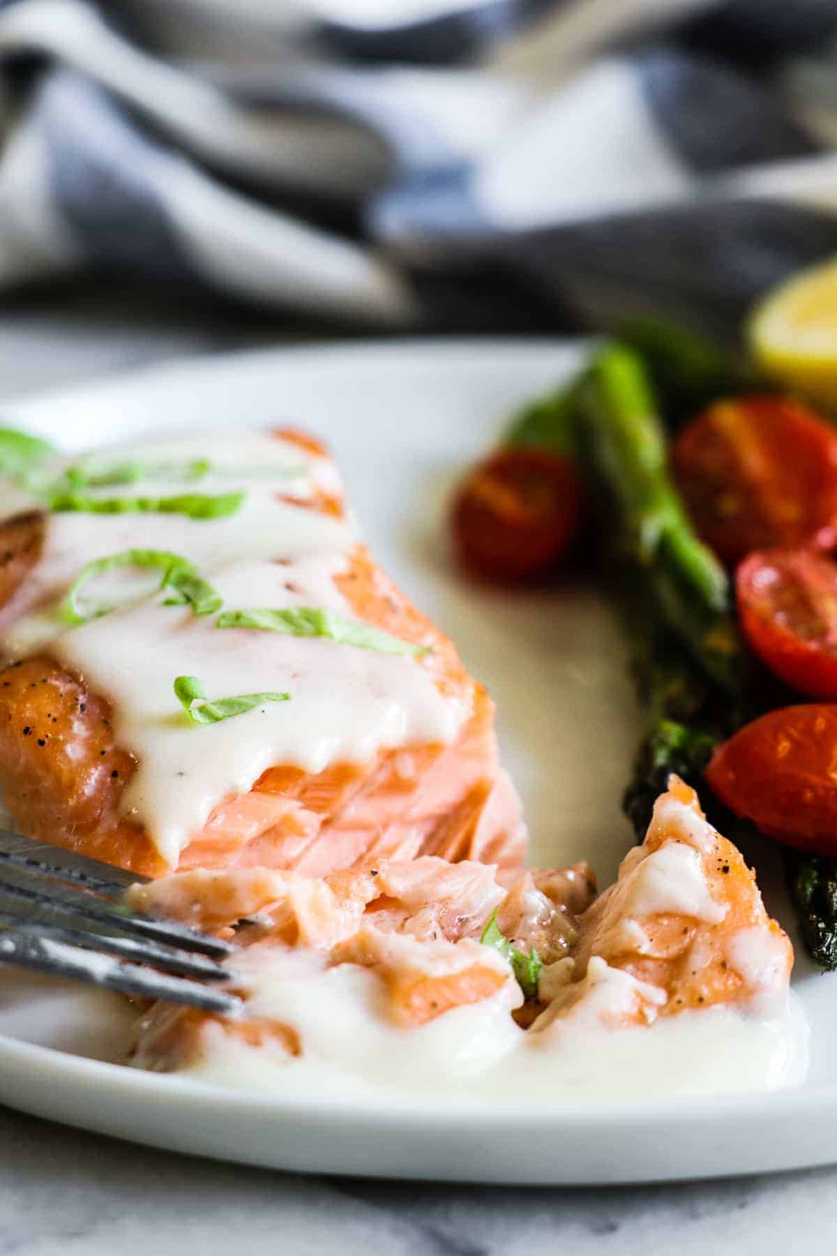 Ce saumon au four facile à préparer est recouvert d'une sauce au parmesan crémeuse et savoureuse. Moins de 30 minutes sont nécessaires pour cette recette de dîner facile !