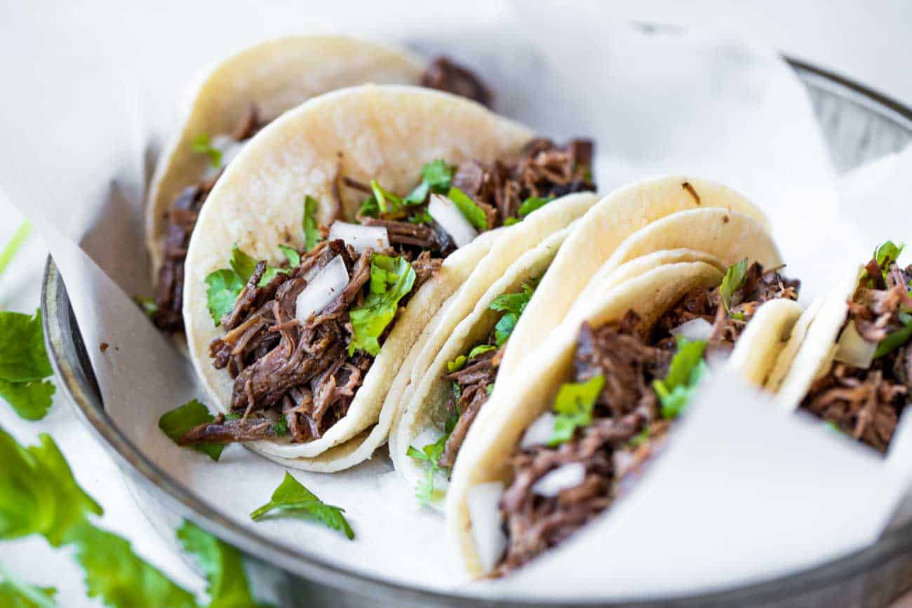 Barbacoa mijoté dans des tortillas de maïs blanc pour des tacos de rue.