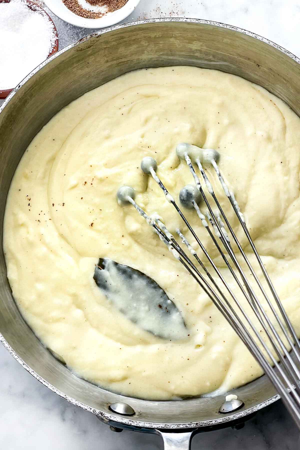 Sauce béchamel dans une casserole avec un fouet foodiecrush.com
