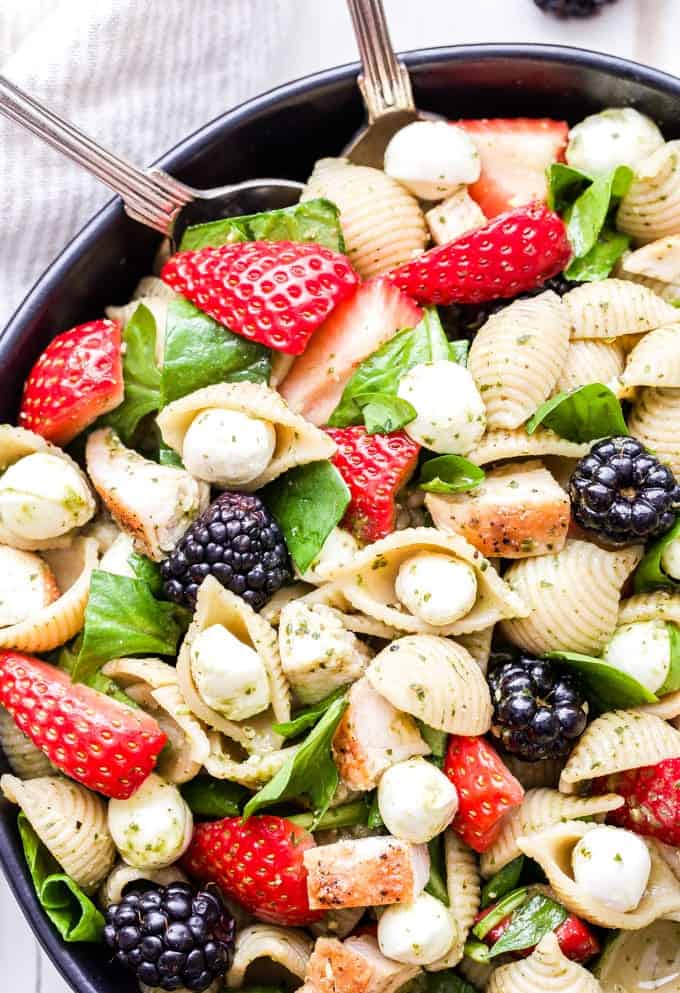 Cette salade de pâtes au poulet et au pesto de baies est un plat principal savoureux et facile à préparer. Toutes les saveurs de la salade caprese, mais en utilisant des baies à la place des tomates ! #pastasalad #pesto #fraises #poulet