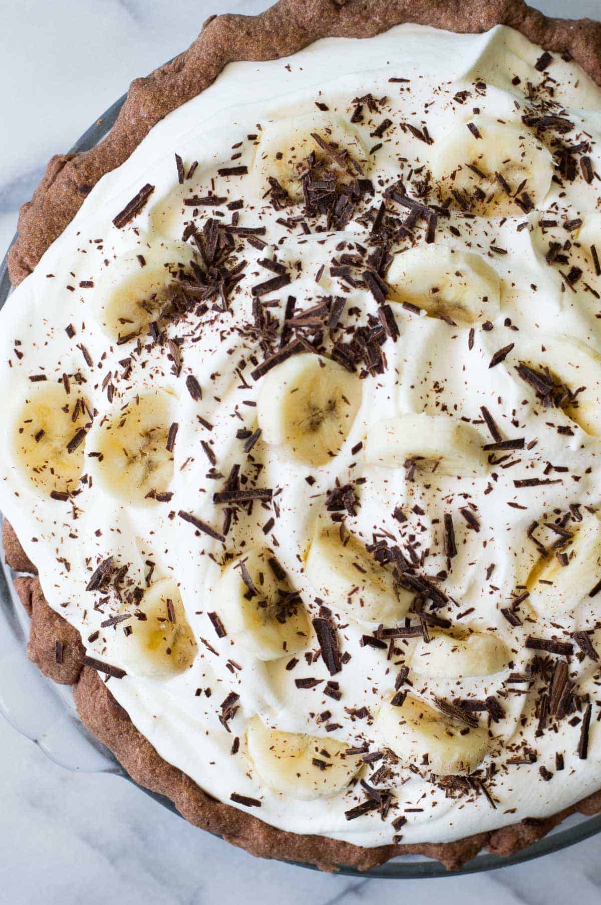 Tarte à la crème au chocolat et à la banane. Croûte de tarte au chocolat garnie de couches de crème au chocolat, de bananes et de crème à la vanille. Le tout recouvert d'une épaisse couche de crème fouettée !