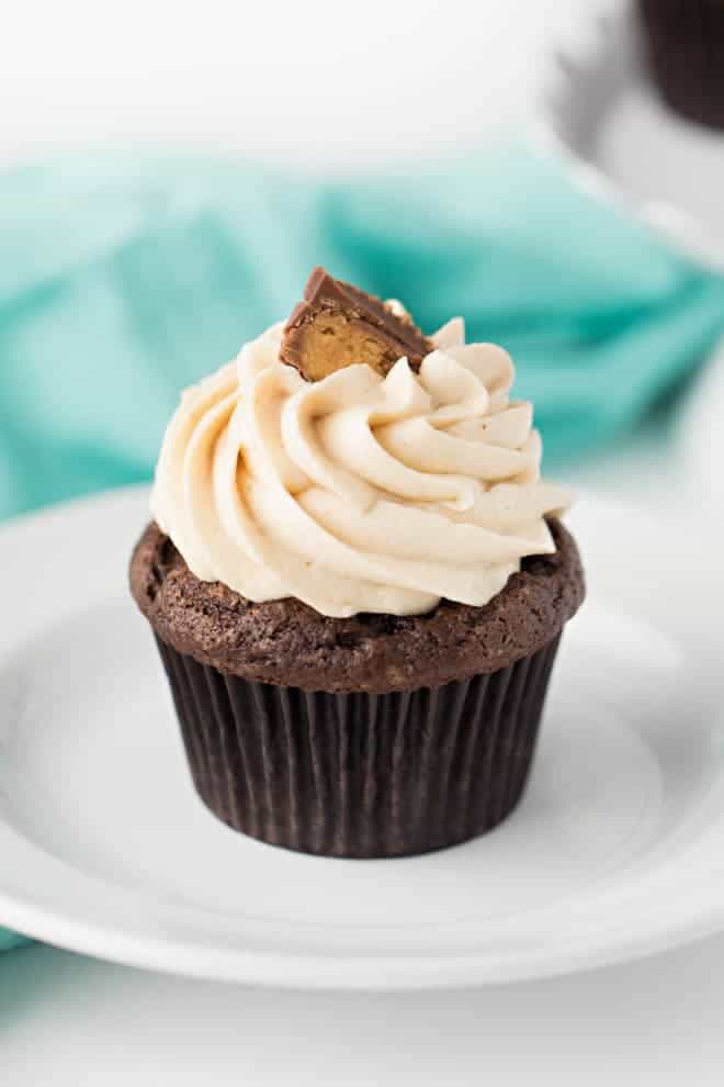un cupcake au chocolat et au beurre de cacahuètes avec glaçage posé sur une assiette blanche