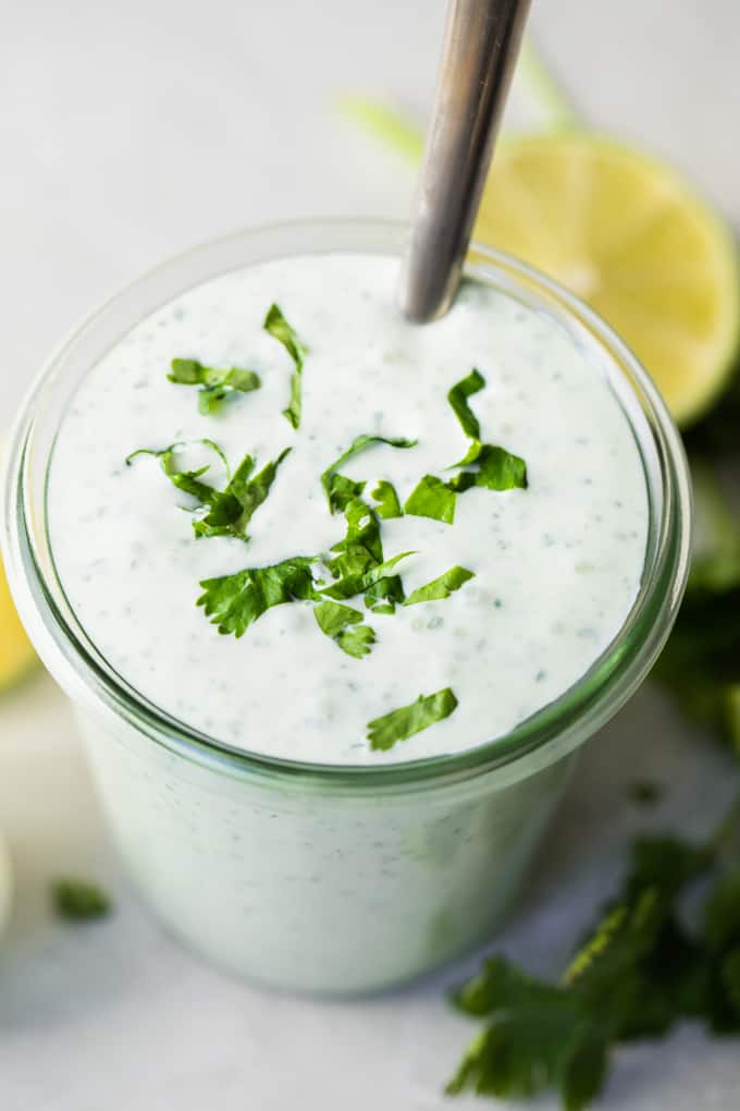 Pot en verre rempli de crème crémeuse à la coriandre et au citron vert.