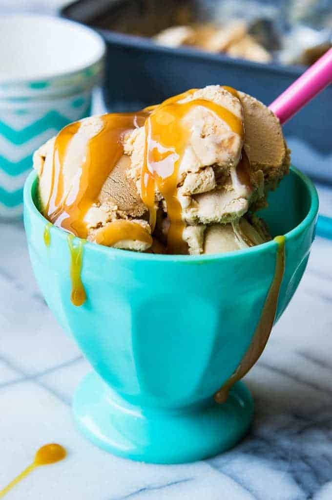 Coupe de glace remplie de crème glacée au dulce de leche maison et garnie d'un filet de caramel.