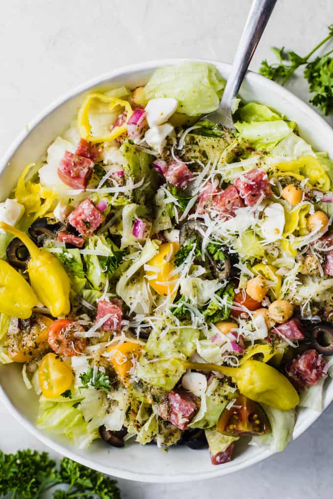 Salade de côtelettes italiennes, laitue avec des dés de salami, tomates, pois chiches, tomates, oignons rouges et autres, le tout arrosé de vinaigrette italienne et garni de pepperoncinis entiers.