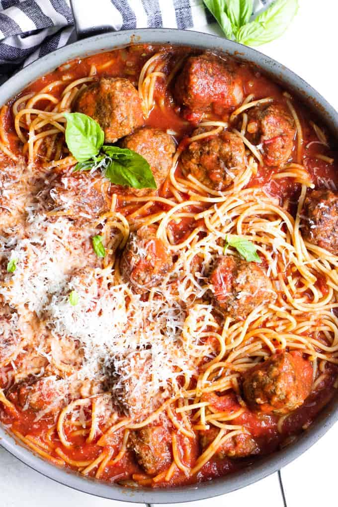 Poêle remplie de spaghettis et de boulettes de viande faits maison.