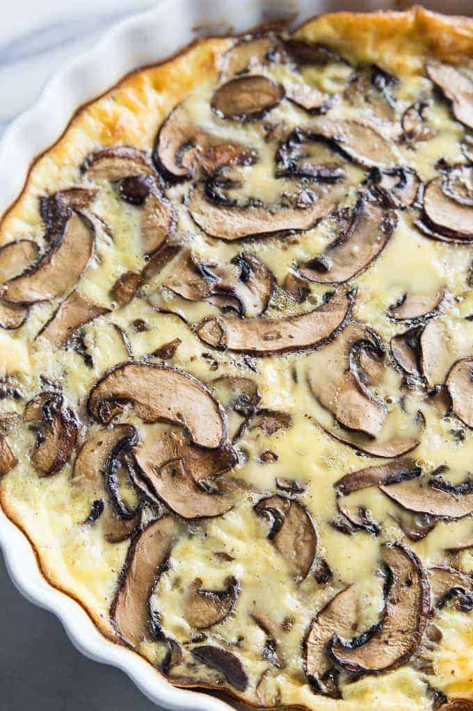 Quiche aux champignons ! Je sais, je sais, les champignons ! Les champignons semblent être dans la même catégorie que les oignons, c'est juste une de ces garnitures que les gens aiment ou détestent, il n'y a pas vraiment d'intermédiaire. Personnellement, la seule fois où j'ai aimé les champignons, c'est en les voyant en arrière-plan du dessin animé des Schtroumpfs, ou lorsque mon petit Mario des frères Mario en mangeait un et se transformait en grand Mario ! C'est une bonne chose ! . En dehors de cela, j'ai personnellement une forte aversion pour ces petits champignons funky, lol si c'est même un mot.... Quoi qu'il en soit, la seule fois où je mange des champignons, c'est lorsque mon mari prépare ses délicieux " champignons farcis " (recette à venir), mais en dehors de cela, les champignons et moi ne sommes jamais amis. Cette quiche est très facile à faire, tout comme ma quiche hawaïenne qui est tombée récemment (que vous pouvez trouver en cliquant sur ce lien "insert Link"). Elle est parfaite pour la personne dans votre vie qui aime absolument les champignons ! Et un énorme compliment pour n'importe quel brunch que vous avez planifié. De la baby bella au shitake, en passant par le portobello, vous pouvez vraiment vous lâcher sur cette quiche en ce qui concerne le choix des champignons, en fonction de ce que vous aimez le plus, mais juste pour un avis de non-responsabilité, cette quiche ne vous transformera pas en un grand Mario, mais elle sera certainement délicieuse.