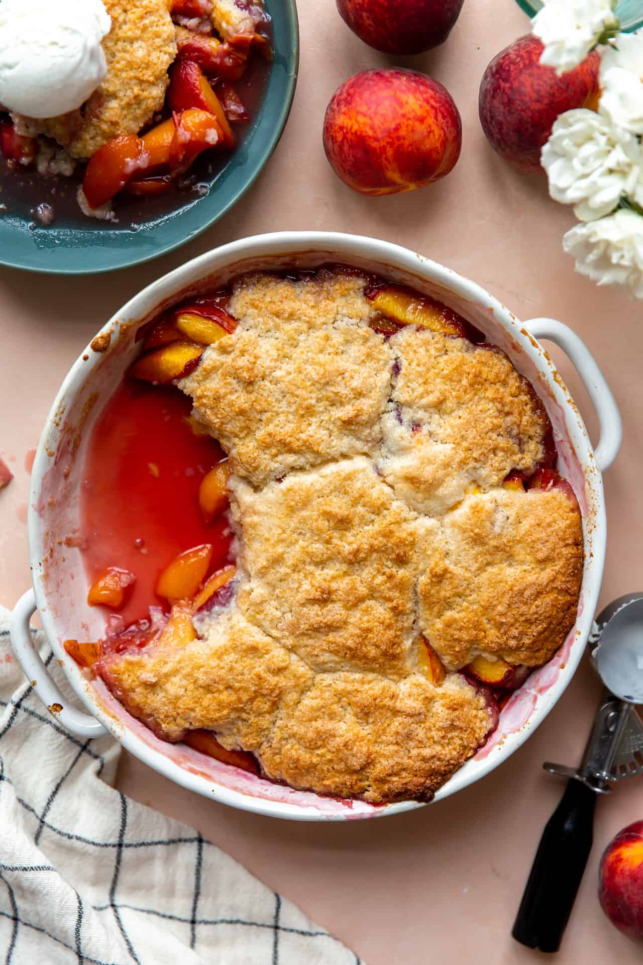 Un cobbler aux pêches cuit au four dans un plat rond.