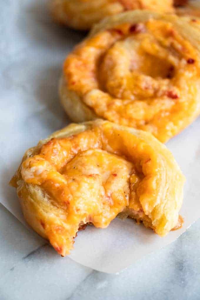 Pinwheel au Pimento Cheese, avec une bouchée manquante et du fromage fondant suintant au centre.