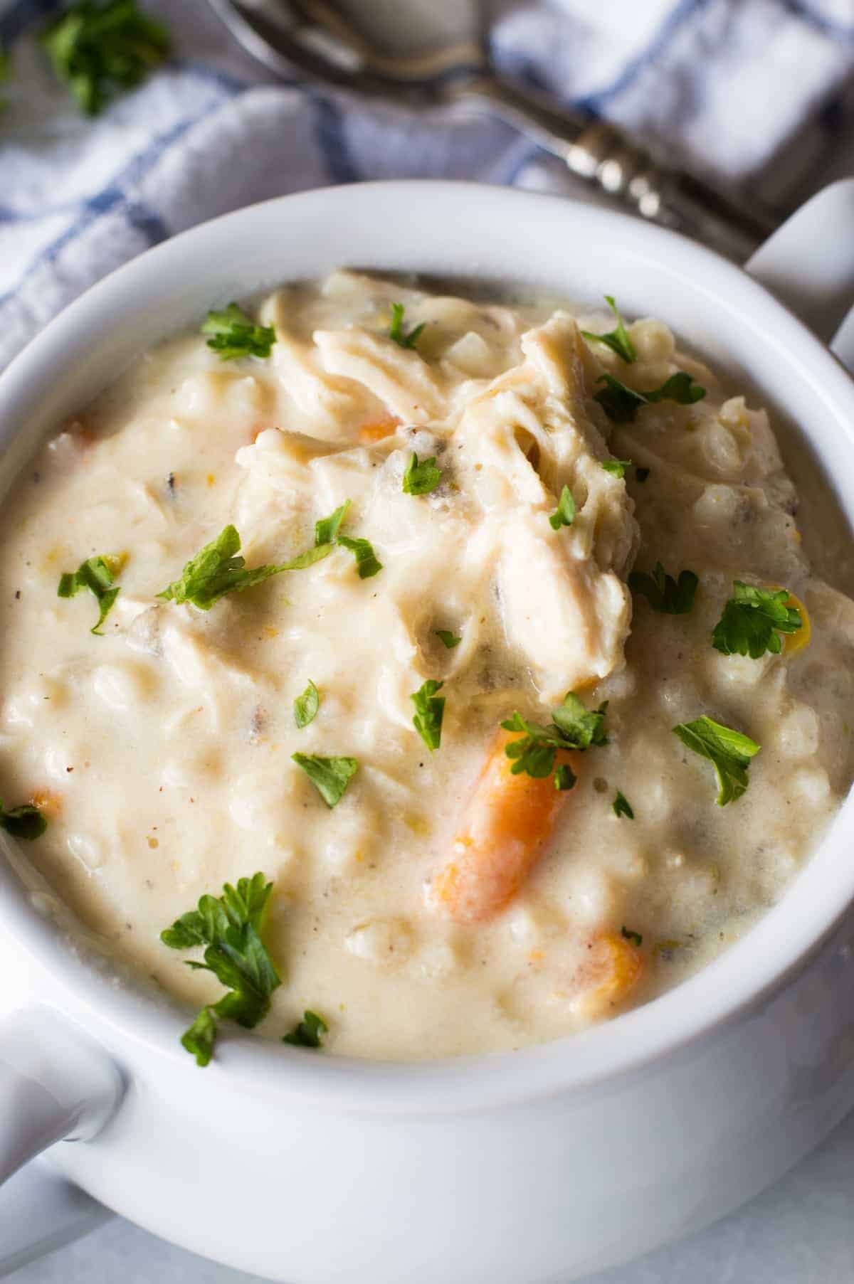 Soupe crémeuse au poulet et au riz sauvage à la mijoteuse ! Cette soupe est ultra crémeuse, ultra savoureuse, et le meilleur ? Il n'y a pas de crème ni de beurre ! C'est la version allégée parfaite d'un plat réconfortant classique.