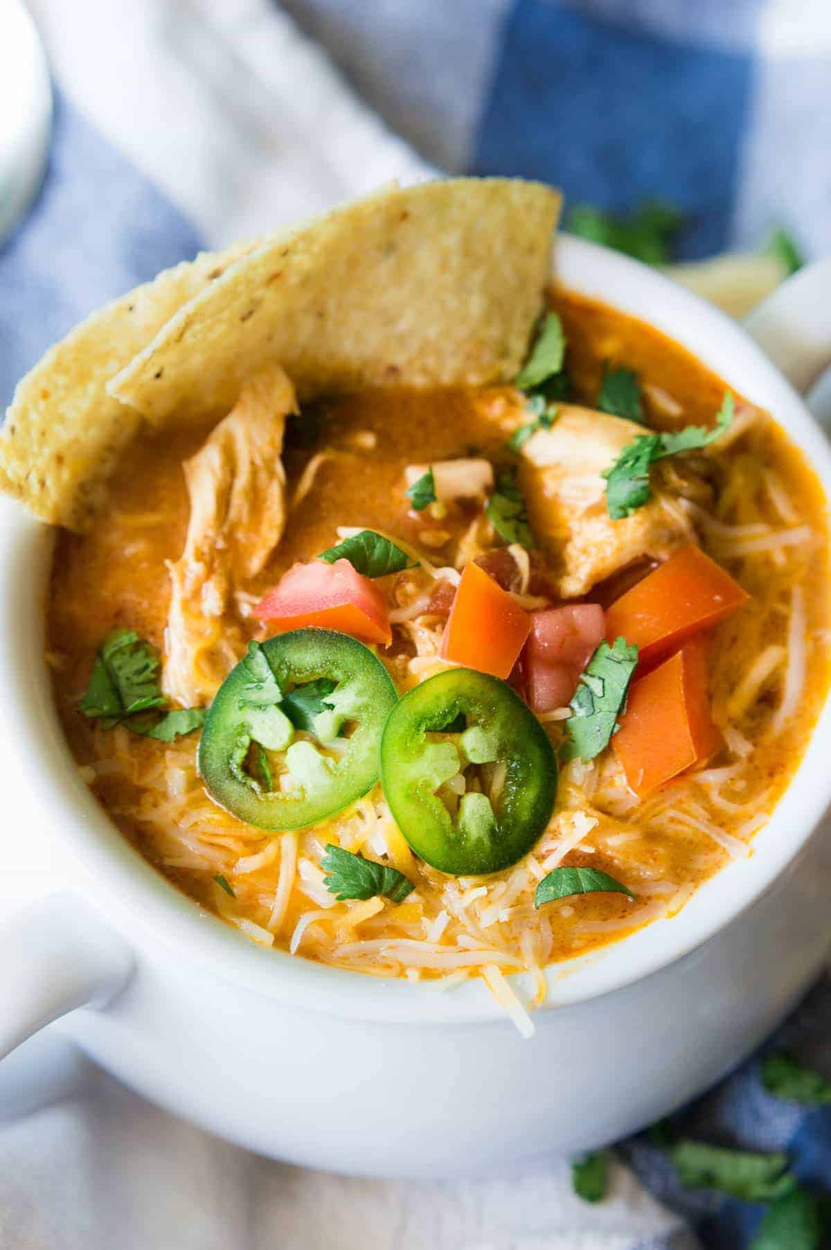 Soupe au poulet King Ranch à la mijoteuse. Cette soupe FACILE a le même goût que la bien-aimée casserole de poulet King Ranch. Elle est remplie de fromage, de morceaux de poulet juteux et de tonnes de saveur ! Il suffit de charger la mijoteuse et de laisser mijoter cette soupe pendant la journée pour la déguster au dîner !