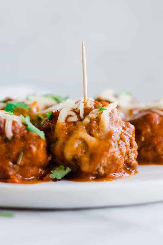 Boulettes Tex Mex Chorizo Enchilada sur une assiette avec des cure-dents.