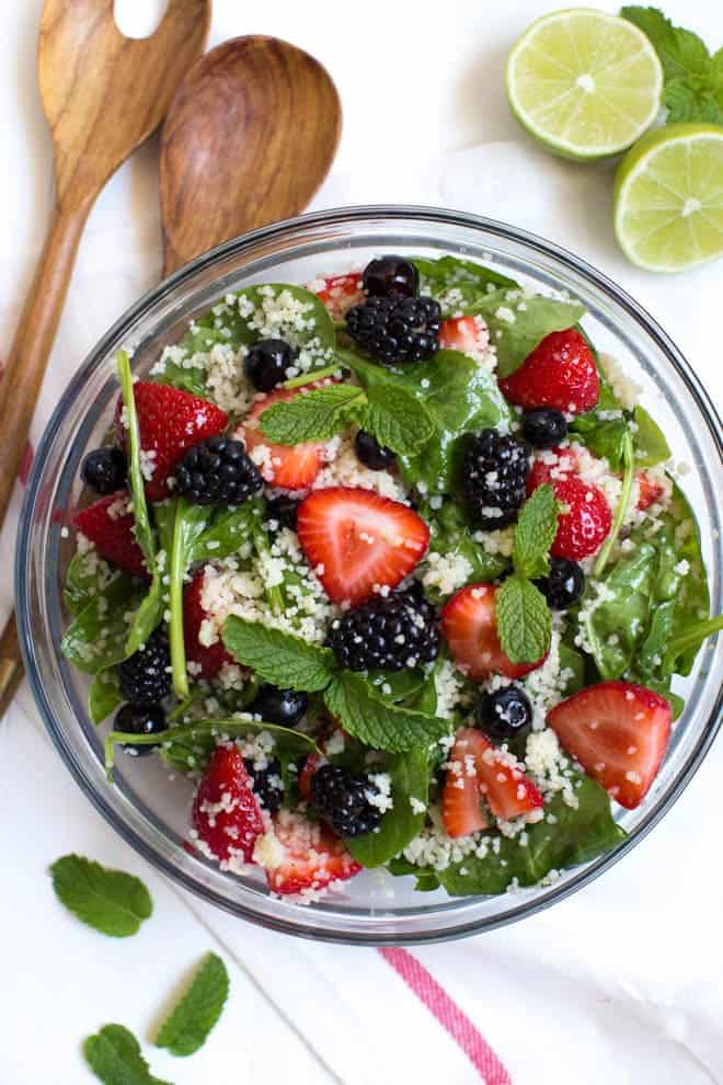 La salade de couscous aux trois baies avec vinaigrette miel-lime-menthe combine le couscous avec des épinards frais, des fraises, des myrtilles et des mûres. Arrosez la salade de la vinaigrette maison miel-limette-menthe pour créer un ajout léger et savoureux à tout repas !