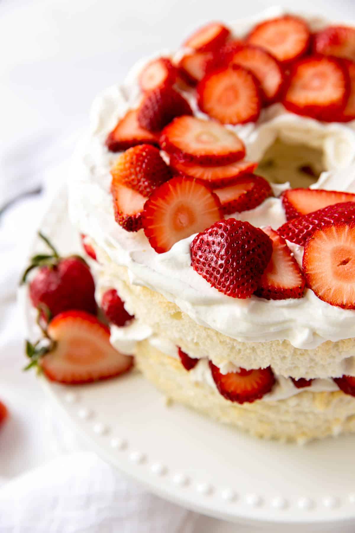 Gâteau des anges garni de fraises et de crème fouettée