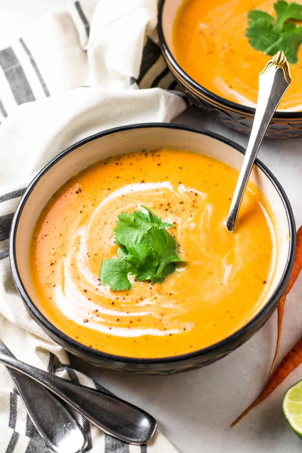 un bol de soupe de carottes avec une cuillère dedans