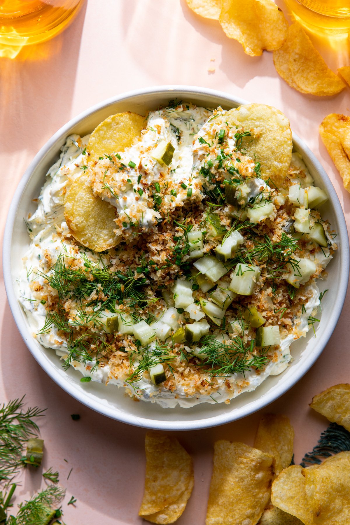 Bol de dip de cornichons à l'aneth garni de pinko grillé, d'aneth frais et de ciboulette.