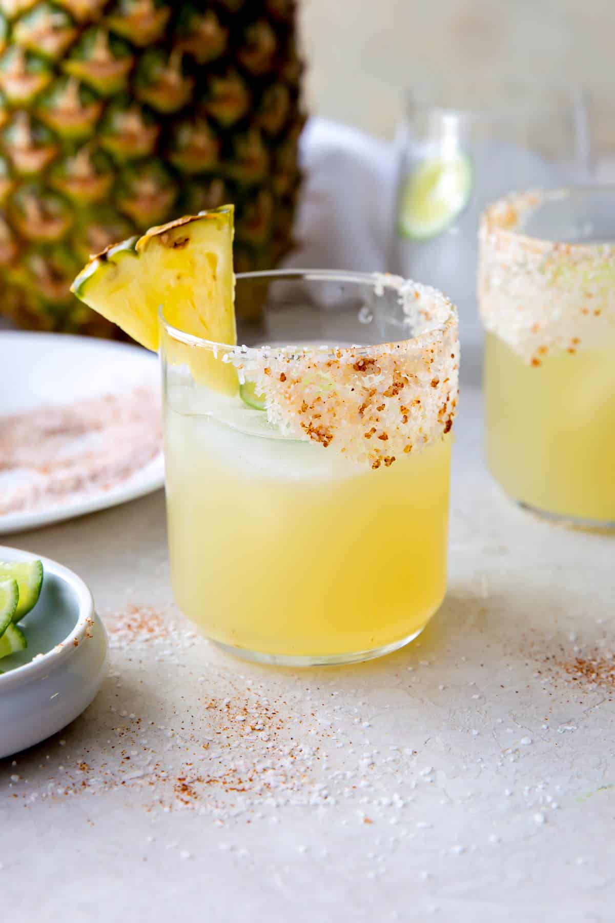 margarita au mezcal dans un verre avec un bord salé et une tranche d'ananas