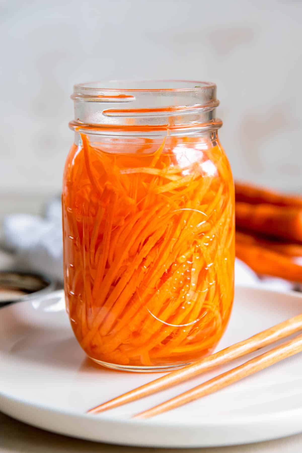 Un pot ouvert de carottes cueillies à la va-vite, posé sur une assiette blanche sur un comptoir.